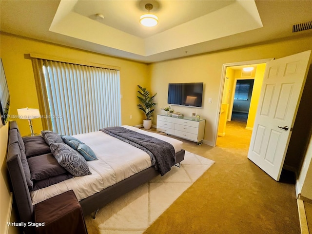 bedroom with a raised ceiling, baseboards, light carpet, and visible vents