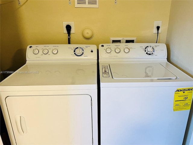 clothes washing area with visible vents and independent washer and dryer