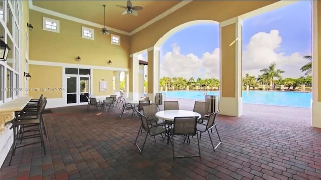 view of patio featuring ceiling fan, outdoor dining space, and a community pool