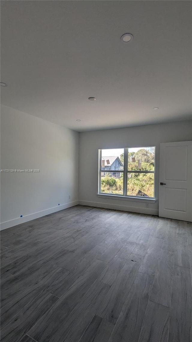 unfurnished room with wood-type flooring