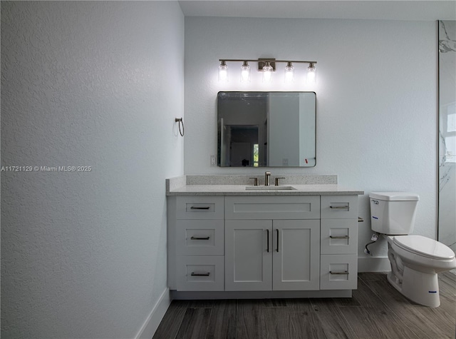 bathroom featuring vanity, hardwood / wood-style floors, and toilet