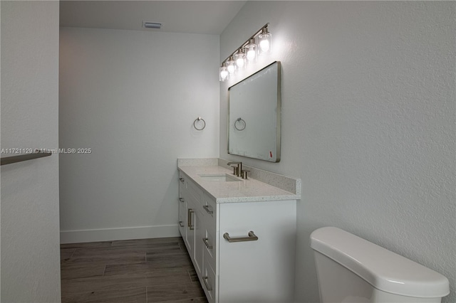 bathroom with vanity, toilet, and wood-type flooring