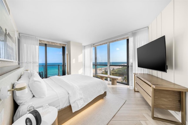 2201 Collins Ave Unit 1128, Miami Beach, FL 33139 - bedroom featuring expansive windows, access to exterior, and light wood-style floors