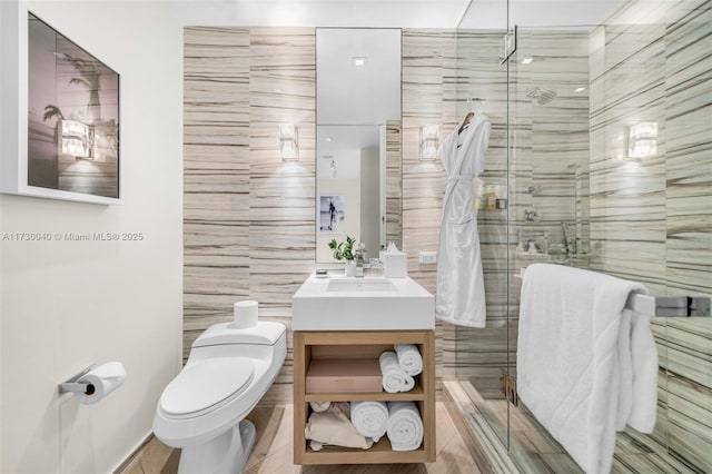 2201 Collins Ave Unit 1128, Miami Beach, FL 33139 - full bathroom with tile walls, vanity, a shower stall, toilet, and tile patterned flooring