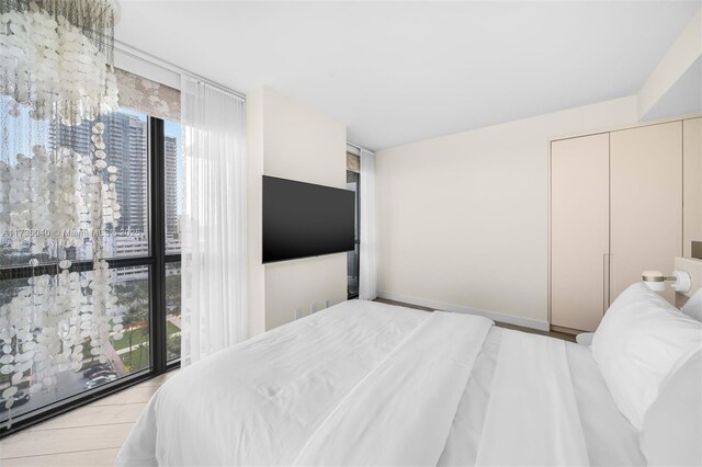 2201 Collins Ave Unit 1128, Miami Beach, FL 33139 - bedroom with a wall of windows, a chandelier, and baseboards