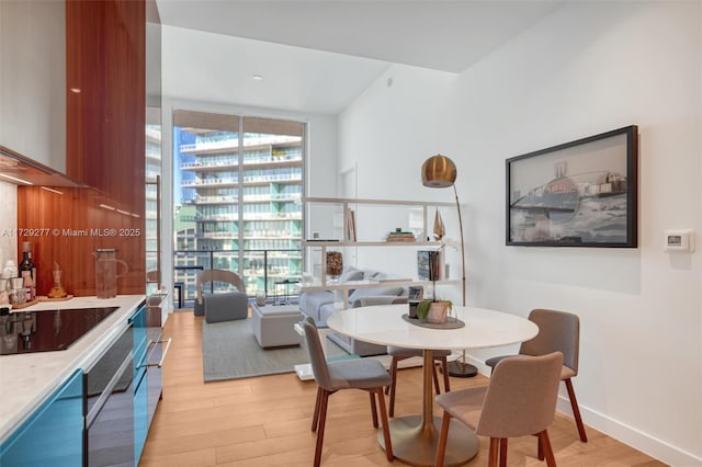 dining area featuring floor to ceiling windows and light hardwood / wood-style floors