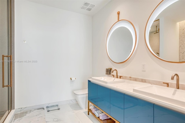 bathroom featuring vanity, toilet, and a shower with shower door