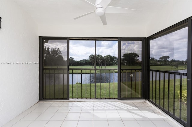 unfurnished sunroom featuring a water view and ceiling fan