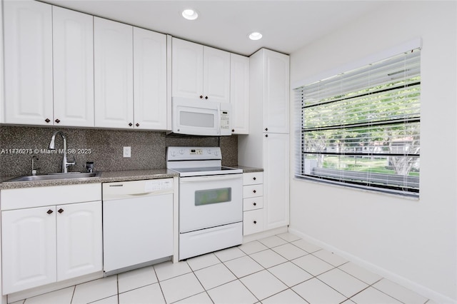 kitchen featuring tasteful backsplash, white cabinetry, sink, light tile patterned floors, and white appliances