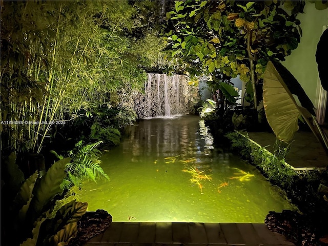 view of water feature with a garden pond