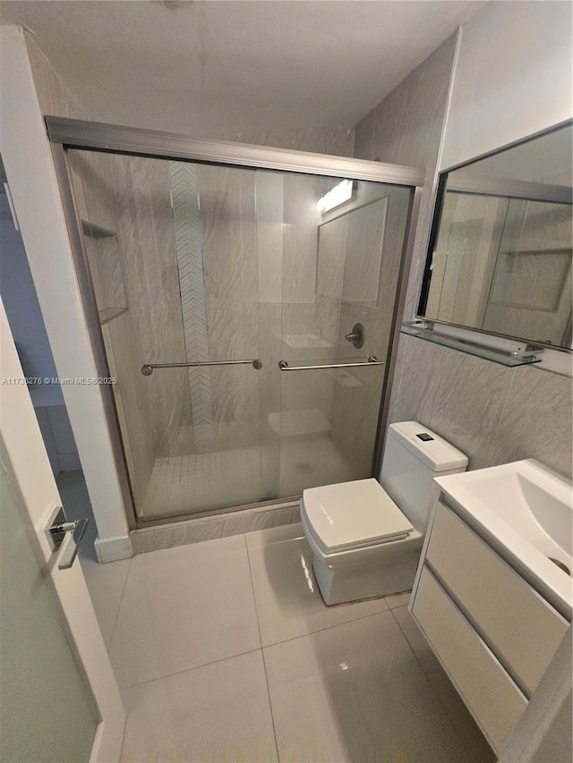 bathroom with vanity, toilet, tile patterned flooring, and a shower with door