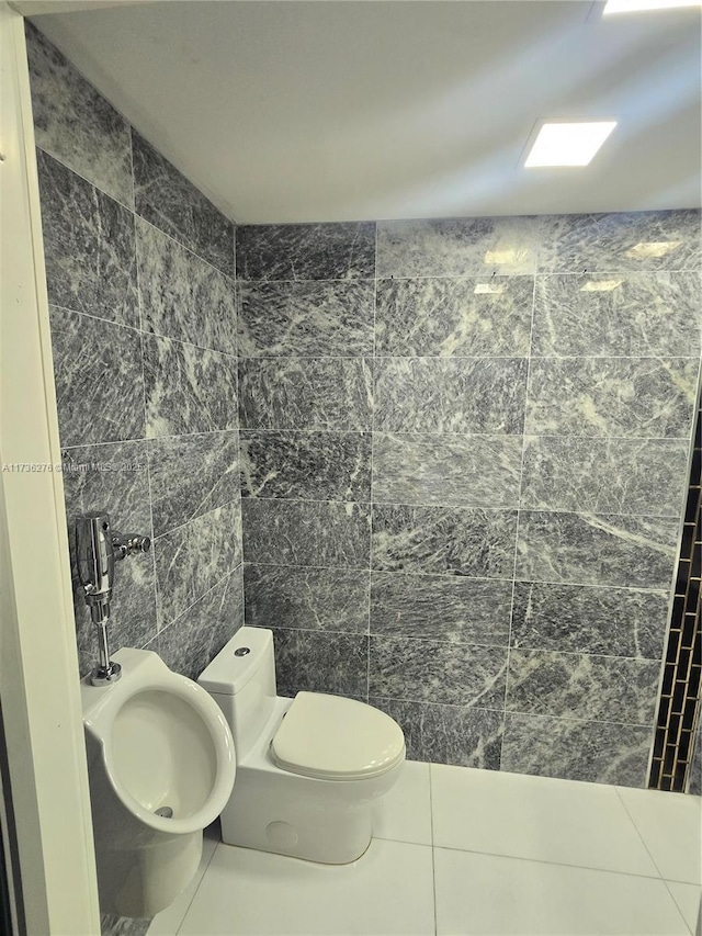 bathroom featuring tile walls, tile patterned floors, and toilet