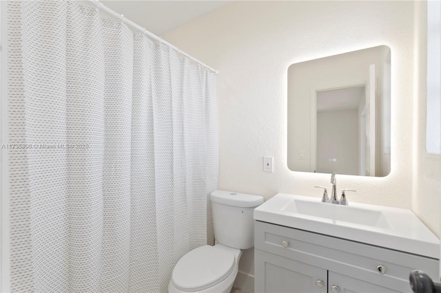 bathroom featuring vanity, toilet, and a shower with shower curtain