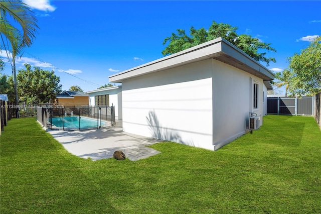 back of property featuring a fenced in pool, a patio area, and a lawn