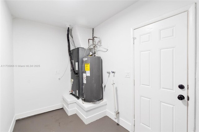 utility room featuring heating unit and electric water heater