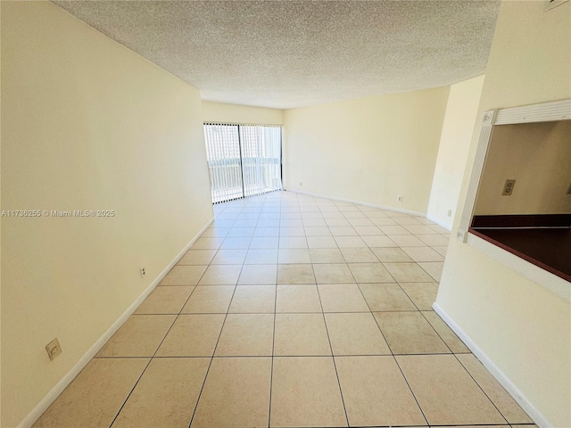 tiled spare room with a textured ceiling