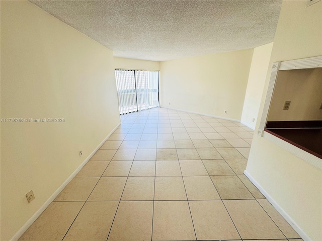 1880 N Congress Ave Unit 210, West Palm Beach, FL 33401 - empty room with a textured ceiling, light tile patterned floors, and baseboards
