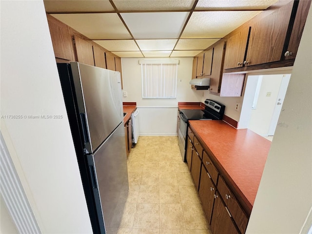 1880 N Congress Ave Unit 210, West Palm Beach, FL 33401 - kitchen with appliances with stainless steel finishes, under cabinet range hood, a drop ceiling, light tile patterned flooring, and dark countertops