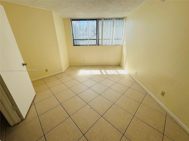 tiled spare room with a textured ceiling