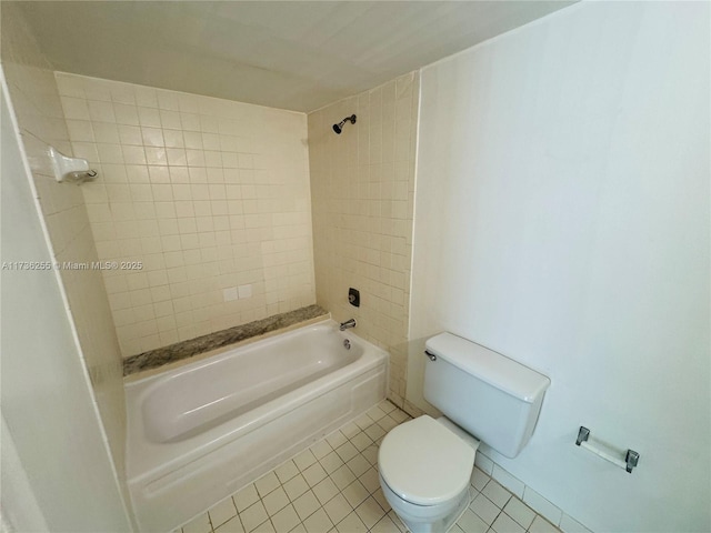 bathroom featuring tile patterned flooring, tiled shower / bath, and toilet