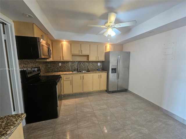 kitchen with sink, appliances with stainless steel finishes, a tray ceiling, light brown cabinetry, and decorative backsplash