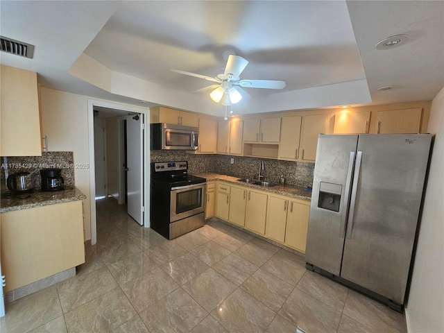 kitchen with sink, ceiling fan, appliances with stainless steel finishes, tasteful backsplash, and light brown cabinets