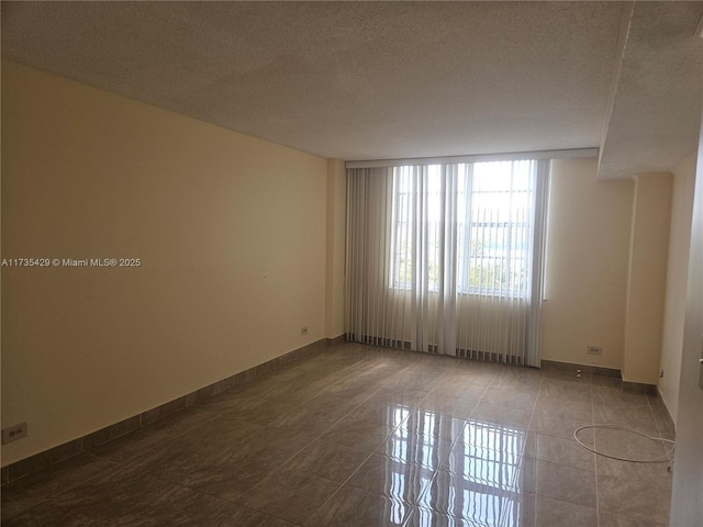 unfurnished room with tile patterned floors and a textured ceiling