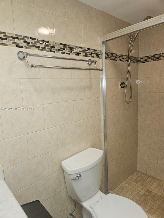 bathroom with a tile shower and toilet