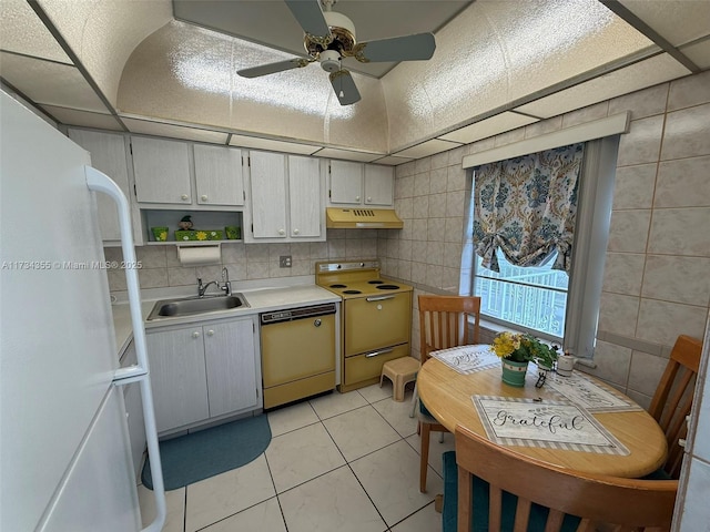 kitchen featuring dishwasher, sink, stove, white fridge, and light tile patterned floors