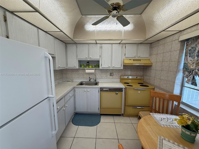 kitchen with sink, range, dishwasher, white fridge, and backsplash