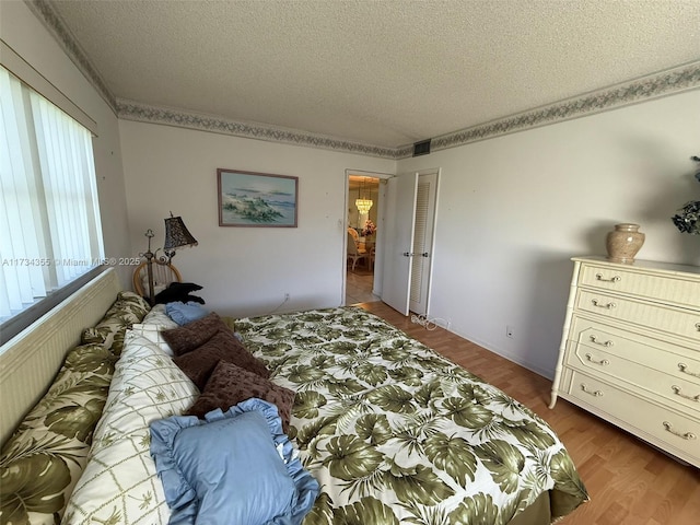 bedroom with hardwood / wood-style floors and a textured ceiling