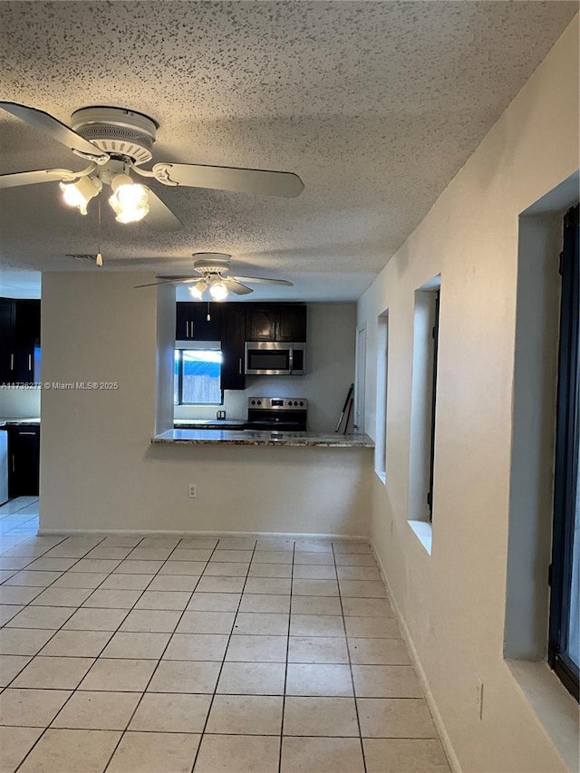 unfurnished living room with light tile patterned floors and a textured ceiling