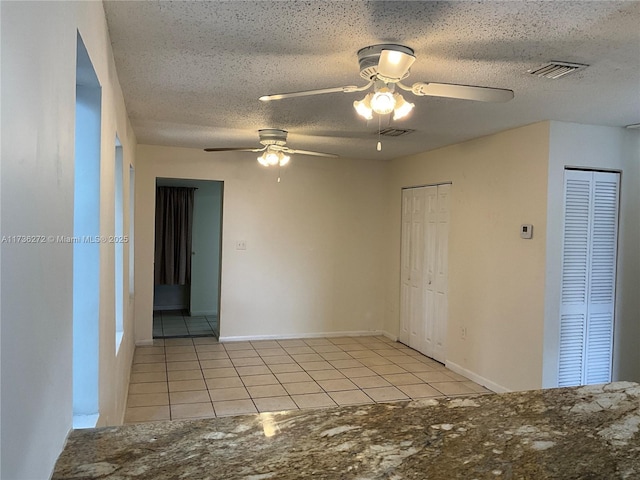 unfurnished room featuring light tile patterned floors and a textured ceiling