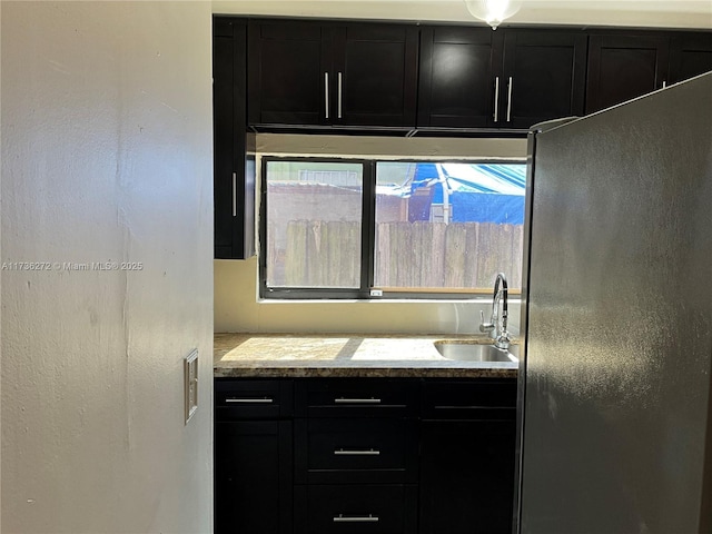 kitchen featuring black refrigerator and sink