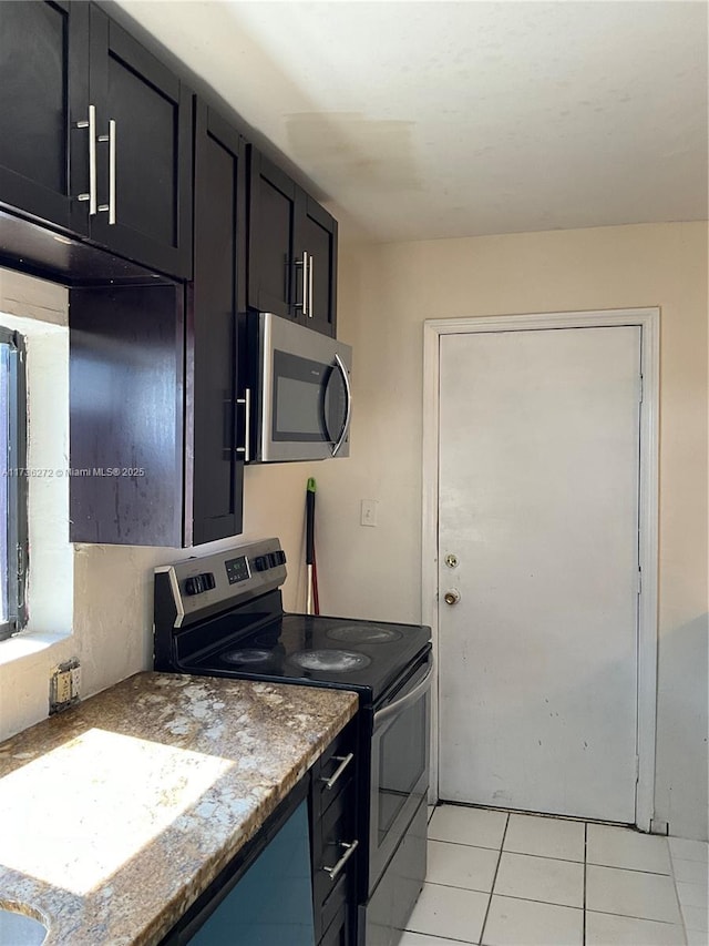 kitchen with appliances with stainless steel finishes, stone countertops, and light tile patterned floors