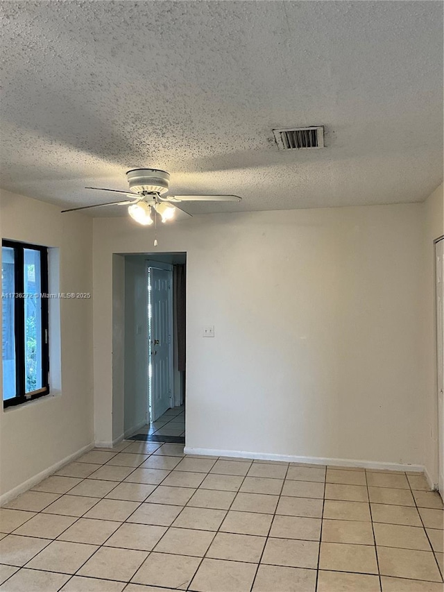 unfurnished room with light tile patterned floors, a textured ceiling, and ceiling fan