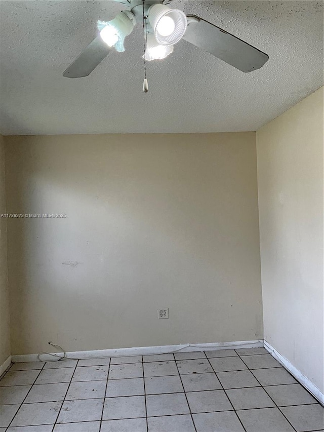 empty room featuring ceiling fan, a textured ceiling, and light tile patterned floors