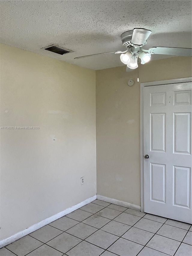 tiled spare room with a textured ceiling and ceiling fan