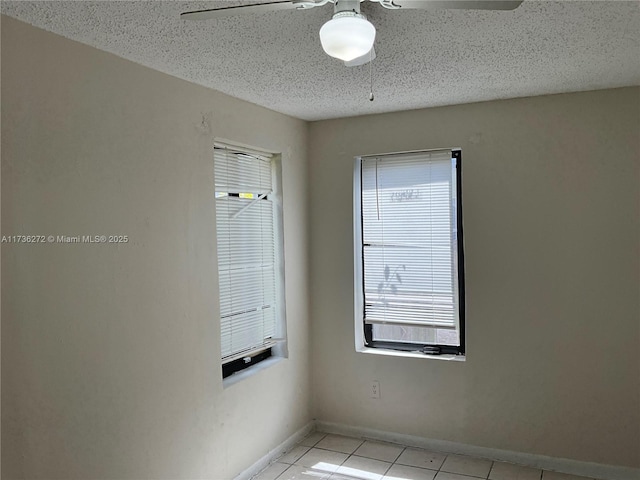 spare room with light tile patterned flooring, a textured ceiling, and ceiling fan