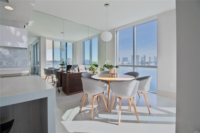 tiled dining space featuring a wall of windows