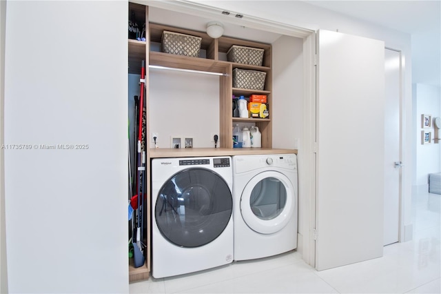 laundry area featuring washing machine and dryer and light tile patterned floors