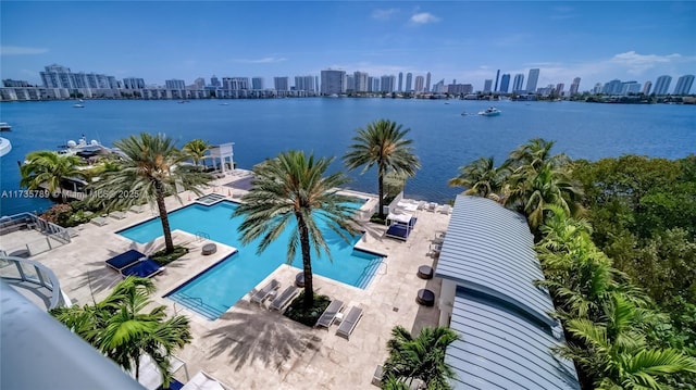 view of swimming pool featuring a patio and a water view