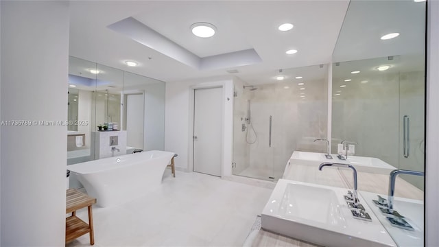 bathroom featuring a raised ceiling, shower with separate bathtub, and vanity