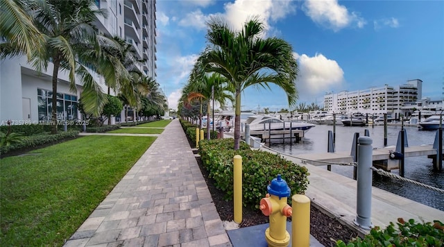 view of dock featuring a water view and a yard