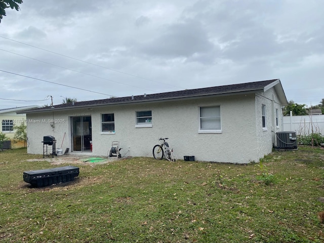 back of house with cooling unit and a yard