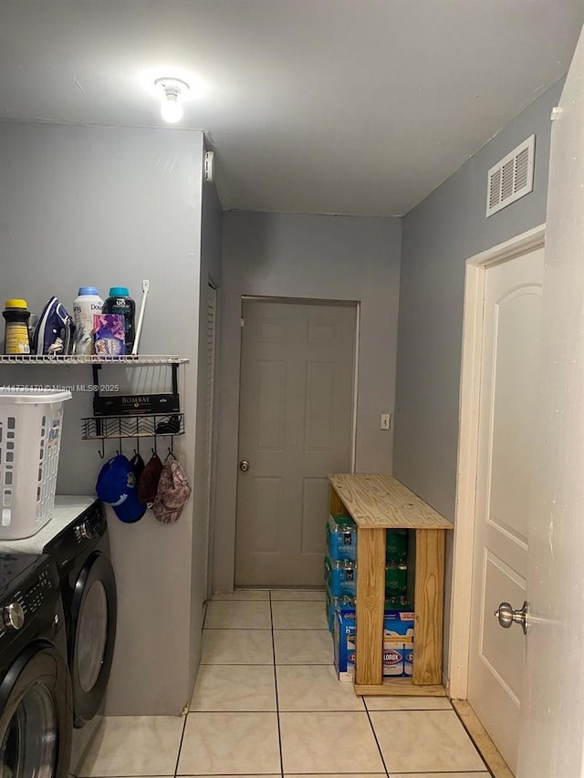 laundry area with washing machine and dryer and light tile patterned flooring