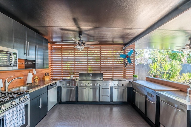 view of patio / terrace with ceiling fan, dark stone counters, sink, and a textured ceiling