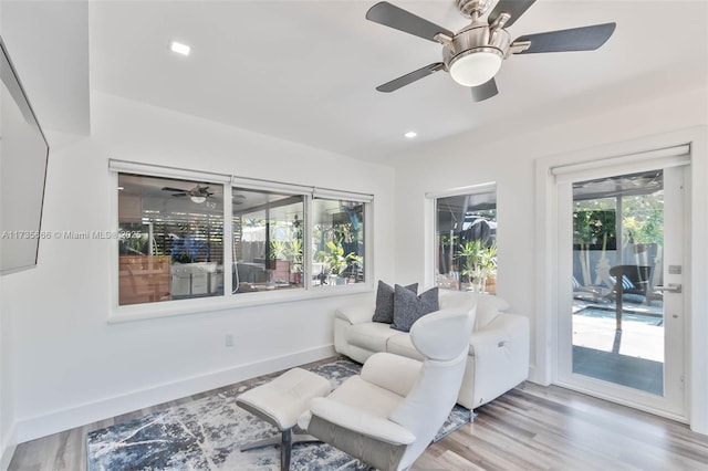 sitting room with ceiling fan and wood-type flooring