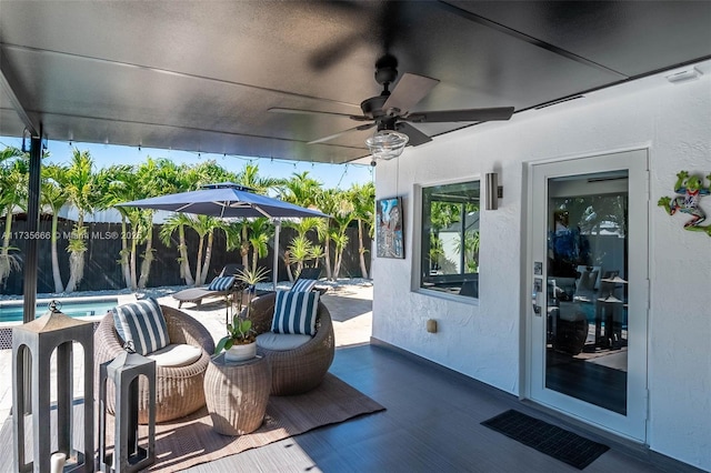 view of patio / terrace with ceiling fan and a fenced in pool