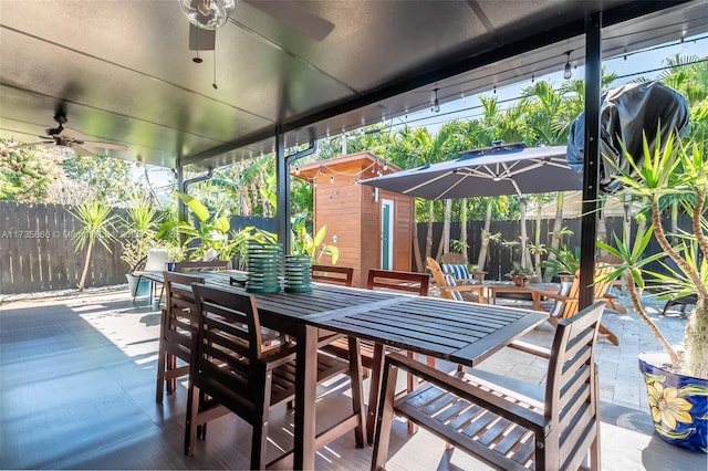 view of patio featuring a shed, area for grilling, and ceiling fan